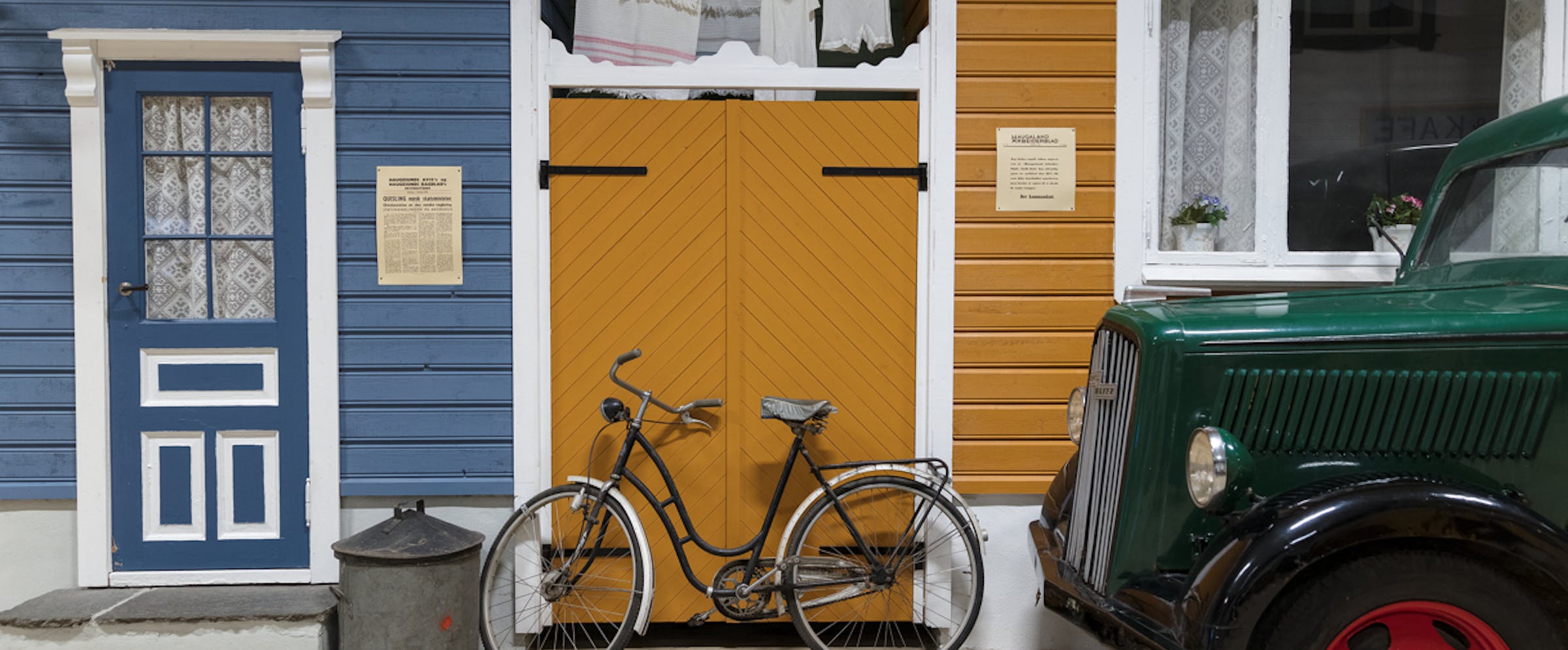 Sykkel og bil parkert foran hus i innendørs gate i Arquebus krigshistorisk museum.